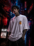 Drip&Verse white 100% cotton oversized tee with a small orange chibi graphic on the left chest. Model is wearing size M.